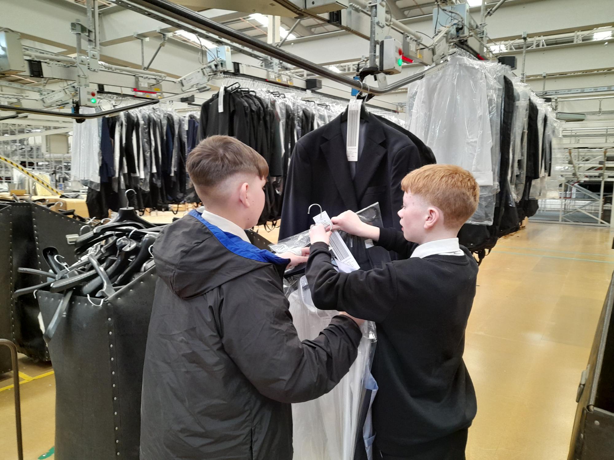 two boys holding clothes inside a warehouse