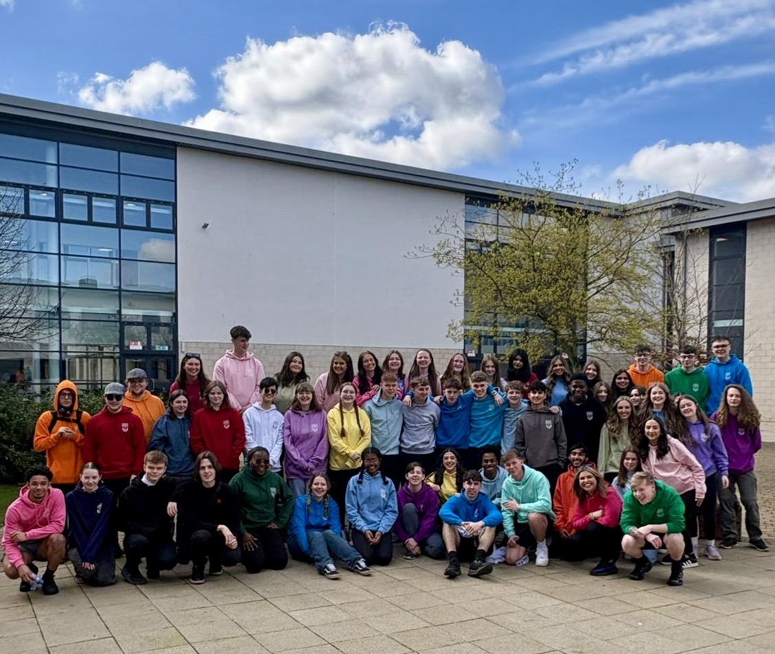 Group photo of school leavers wearing different coloured leavers hoodies