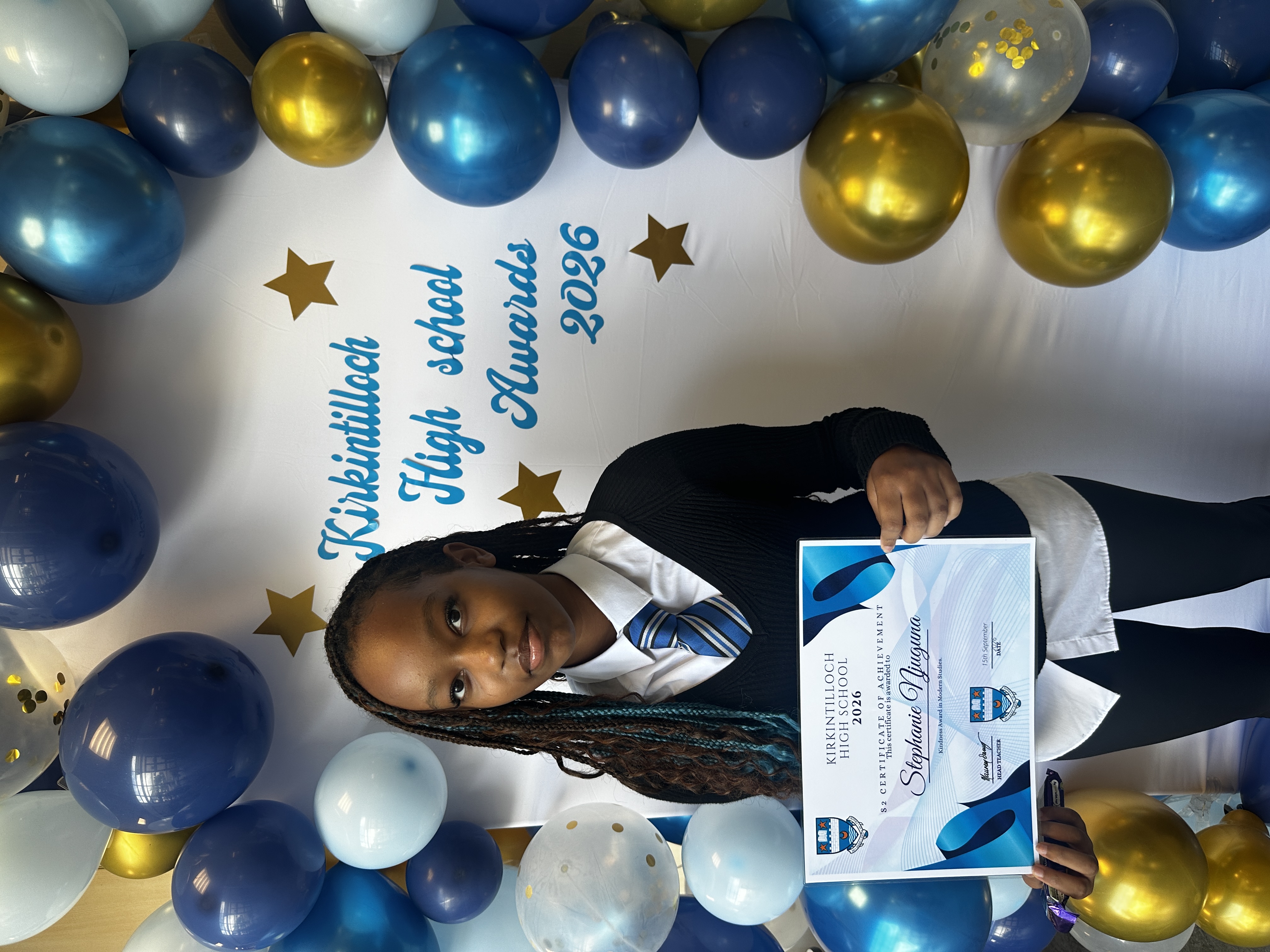 pupil holding a certificate of achievement