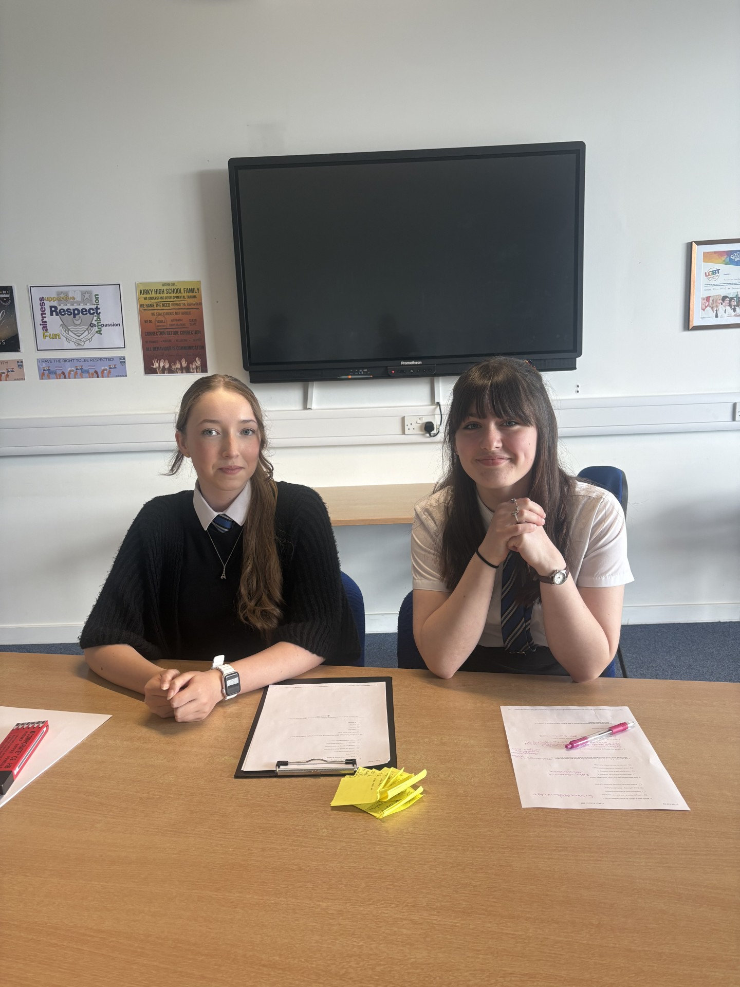 2 pupils sitting at a desk in a classroom