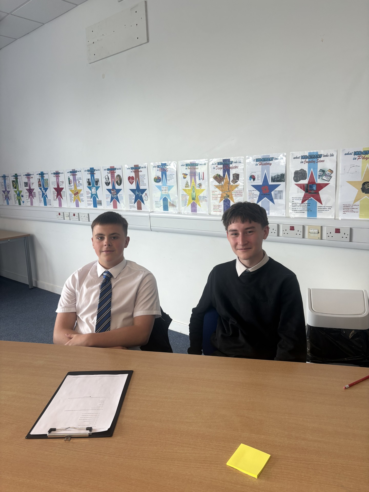 2 pupils sitting at a desk in a classroom