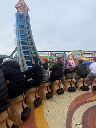 A group of children sitting on a rollercoaster 
